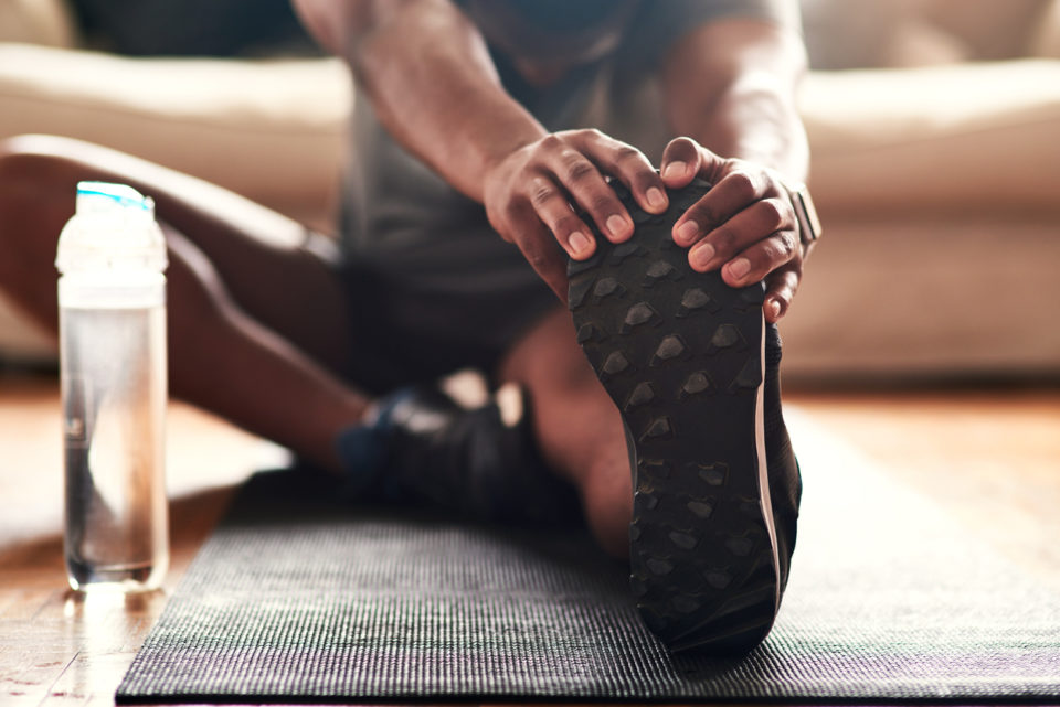 Man stretching on exercise mat