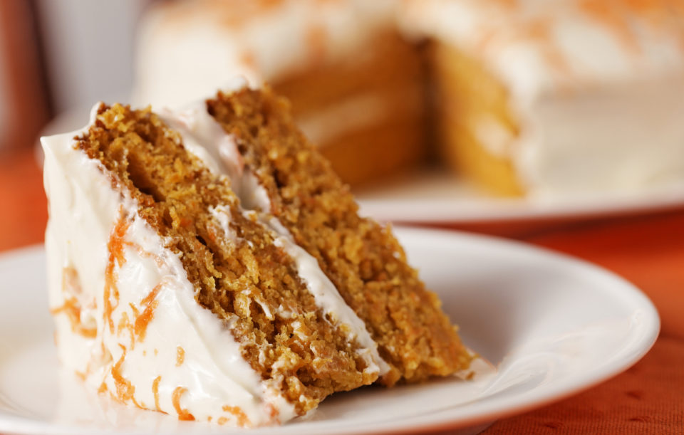 Homemade carrot cake dessert on white plate.