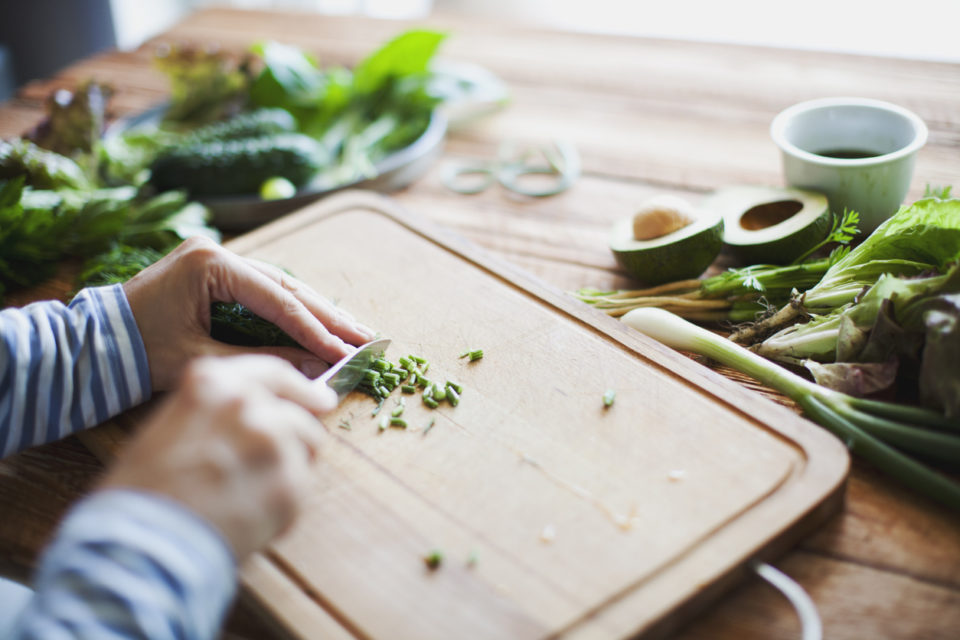 Woman cutting herbs and vegetables