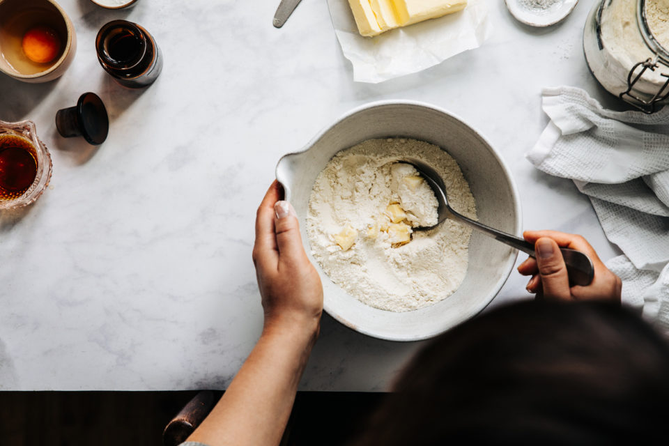 Woman preparing pie dough with flour and butter