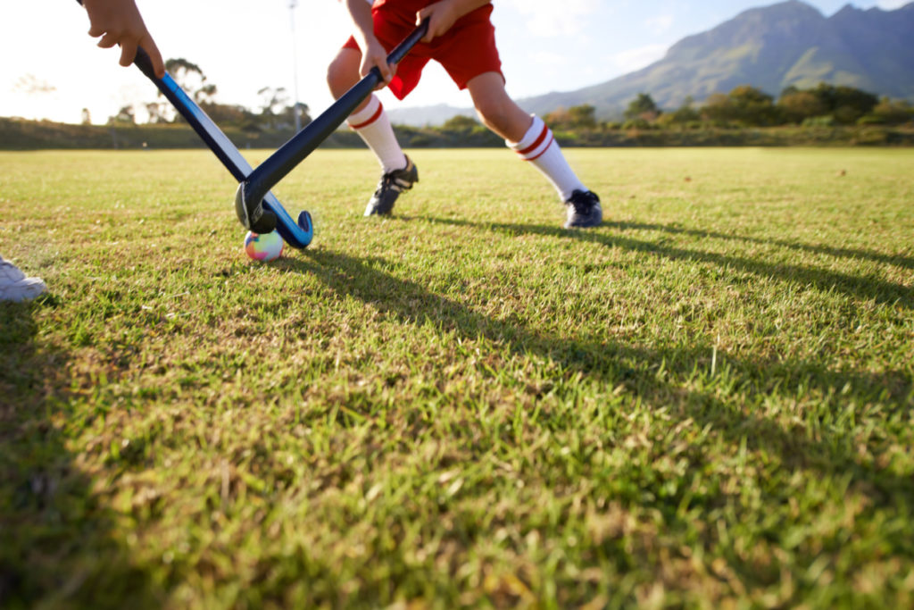 Cropped image of children playing field hockey