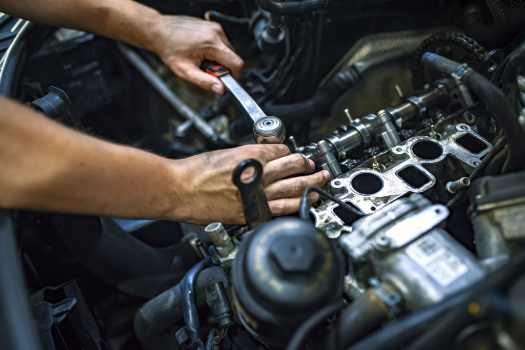 mechanic working on vehicle engine 