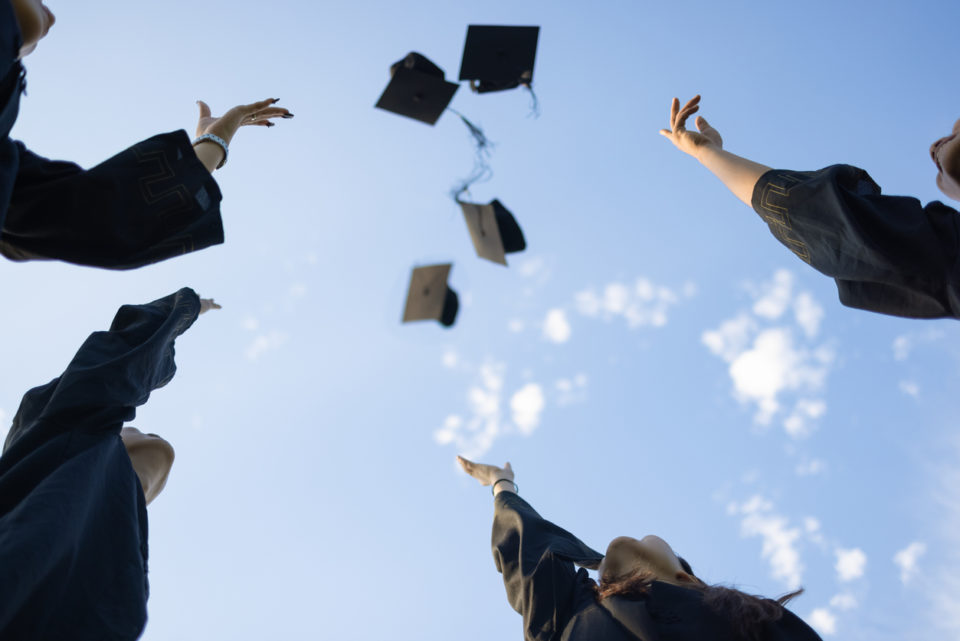 group of graduates throwing their cap