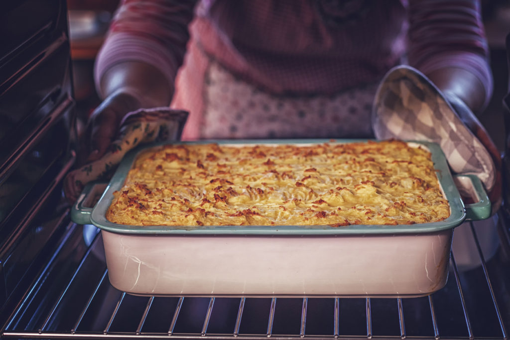 Taking a casserole from the oven.